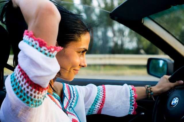 photo of a woman driving a convertible car