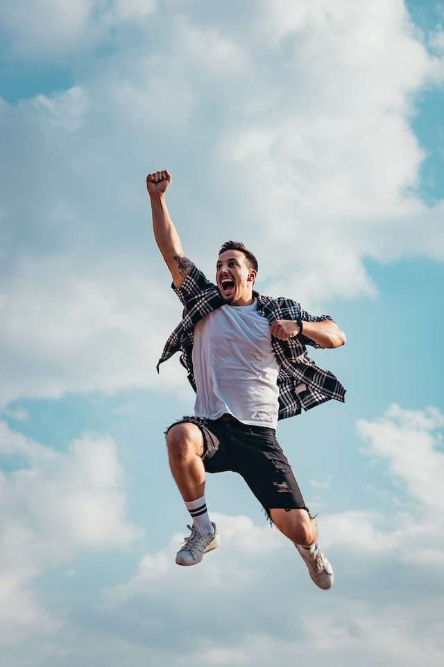 photo of young man celebrating in the air best auto transport company