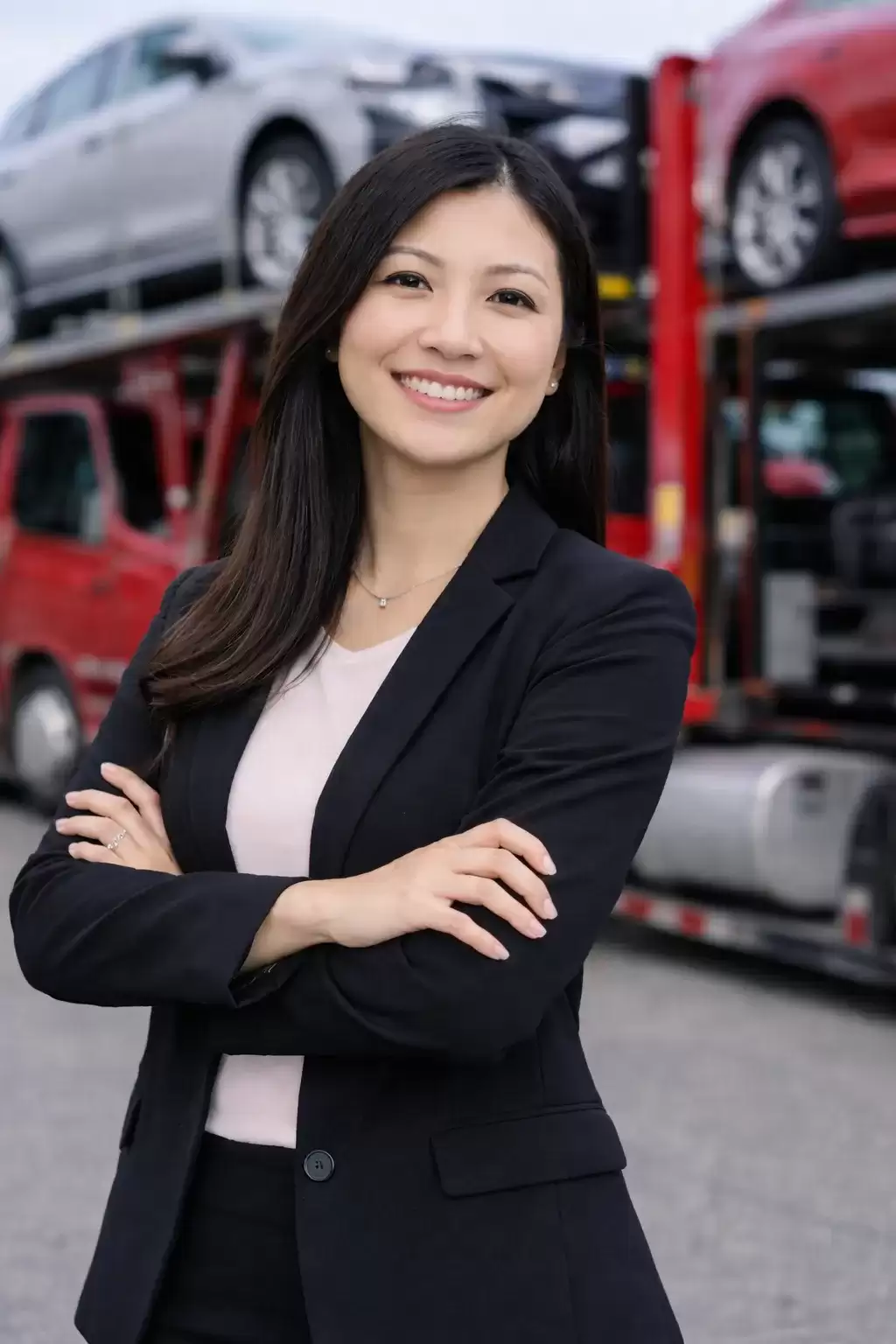 Michigan business woman in front of a full car carrier